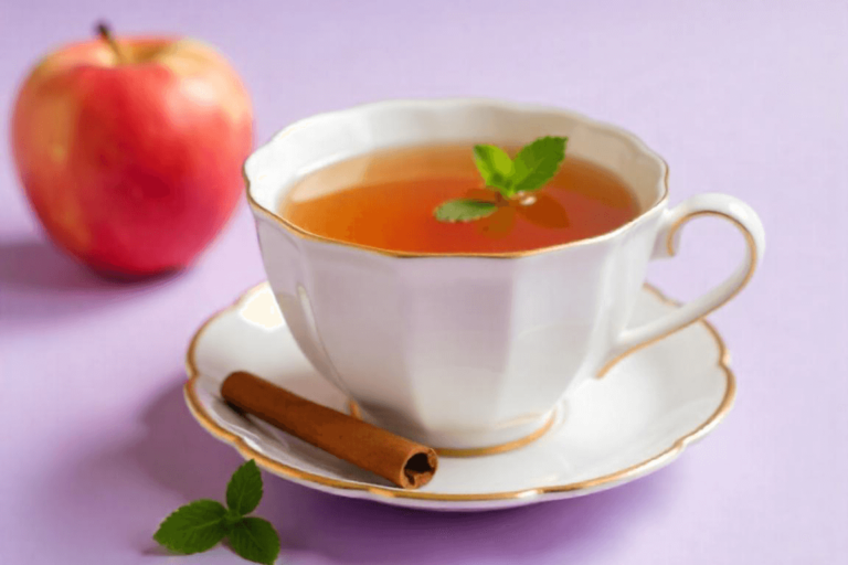Xícara de chá de maçã com canela, com uma maçã ao lado e um pau de canela, criando uma sensação aconchegante.