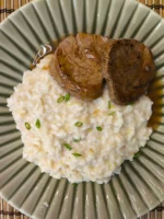 Risoto de queijo brie com alho poró, servido com filé mignon suculento.